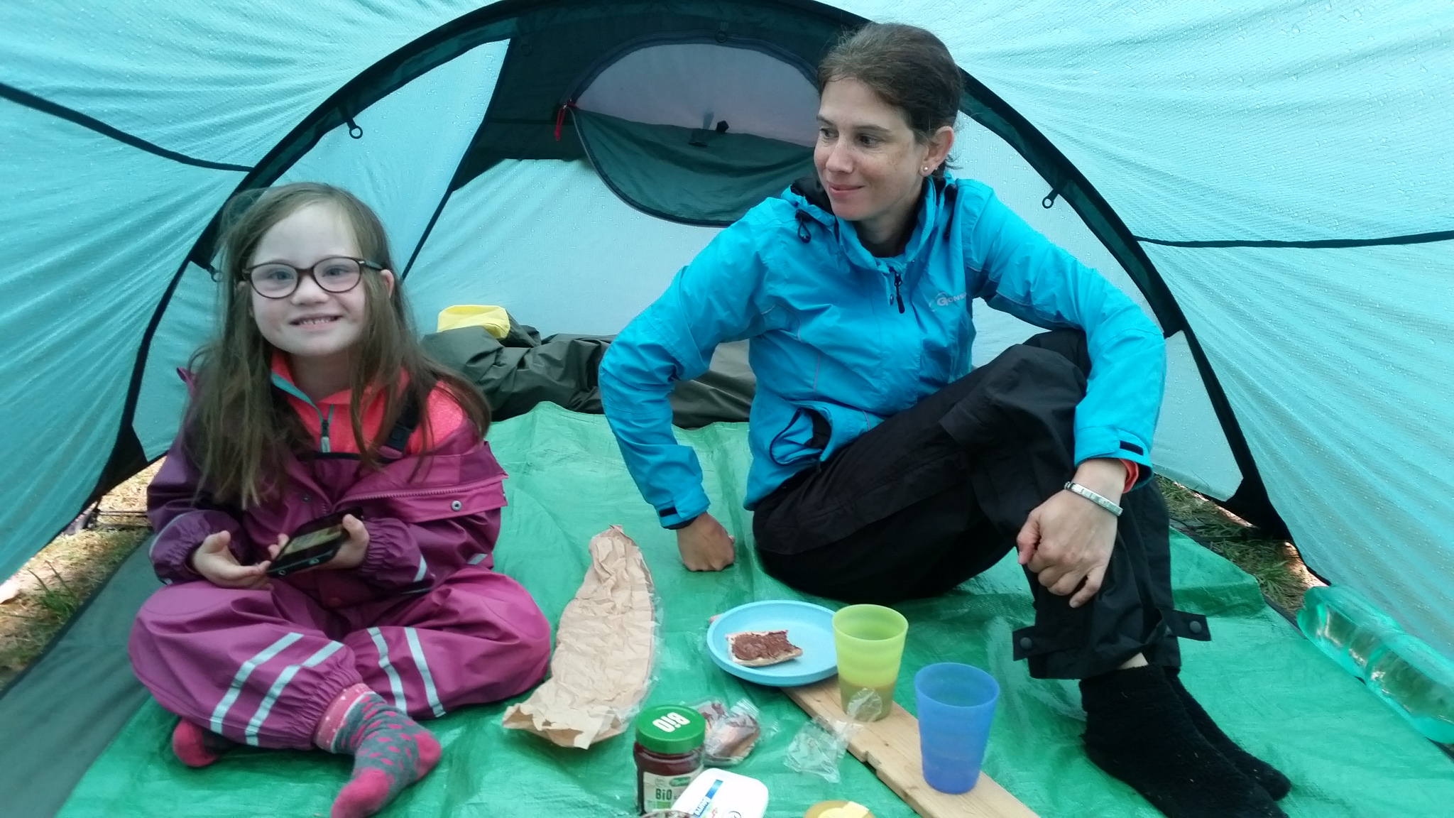 Frühstück während der Regen auf Zeltdach trommelt